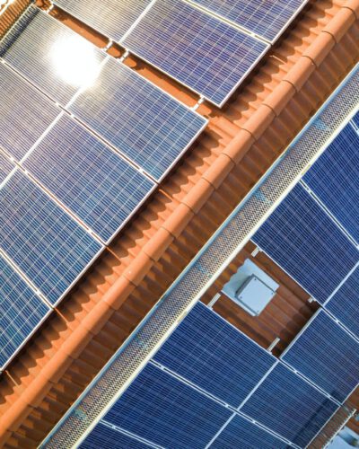 Aerial view of solar photo voltaic panels system on apartment building roof.