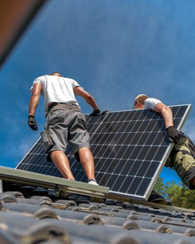 Men worker installing solar photovoltaic panels on roof, alternative energy, saving resources and